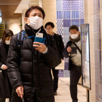 歩行支援スマートフォンアプリを使い、視覚障がい者が日本橋の街中を歩く様子