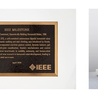 IEEEマイルストーン銘板（左）と人間型自立二足歩行ロボットP2（右）