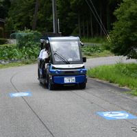 市道を走る「奥永源寺けい流カー」。道路上の黒い線が自動運転を制御するために敷設された電磁誘導線