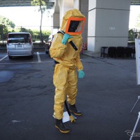 下地処理では、研削材を空気圧で吹き付け、古い塗膜やサビを削り落とす。その際の防護服