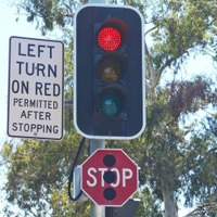 T字路に設けられた感応式の信号機。右折するときは青に変わるのを待つが、左折は、一時停止して安全が確認できれば赤でも曲がることができる。