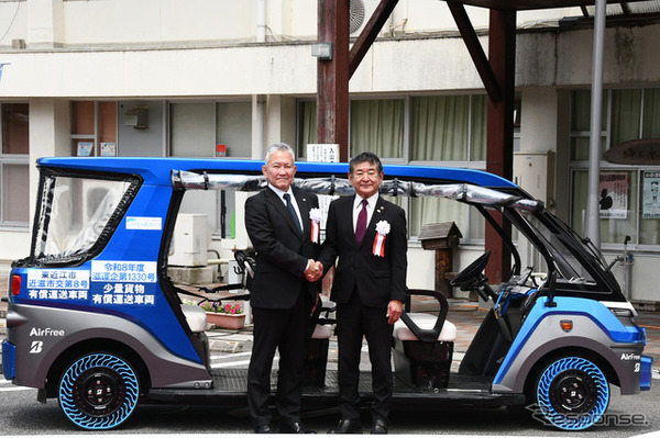 「奥永源寺けい流カー」の前で握手を交わす小椋正清市長（右）とブリヂストンの蓮沼 利幸氏（左）