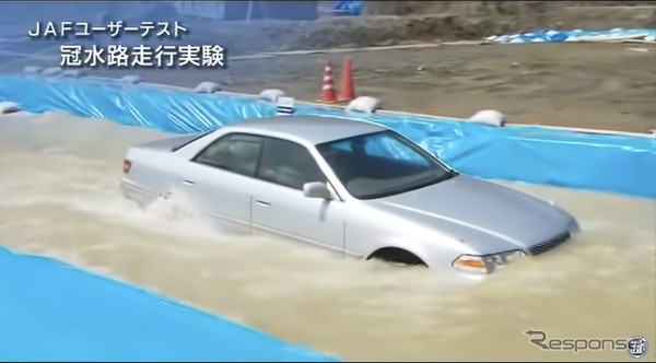 JAFのYouTube動画『冠水路走行テスト～セダンタイプ～』の1シーン。水深60cmの冠水路を時速10kmで走行しているところ。