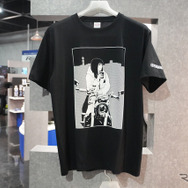 プラザショップで限定販売される加藤ノブキ氏のイラストが描かれたTシャツ