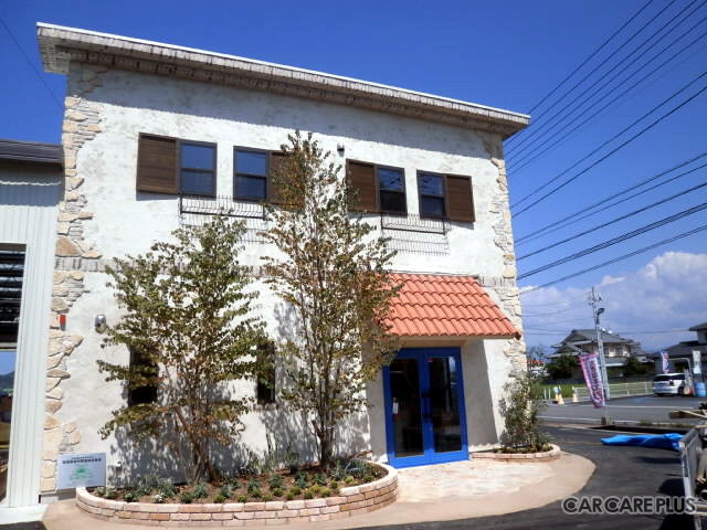 外壁は優しい印象が漂うベージュ色で、店舗入り口の屋根には明るいレンガ色の瓦があしらわれている